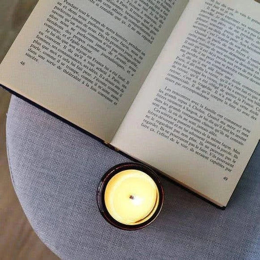 Bougie Made in France non parfumée posée sur une table à côté d'un livre ouvert