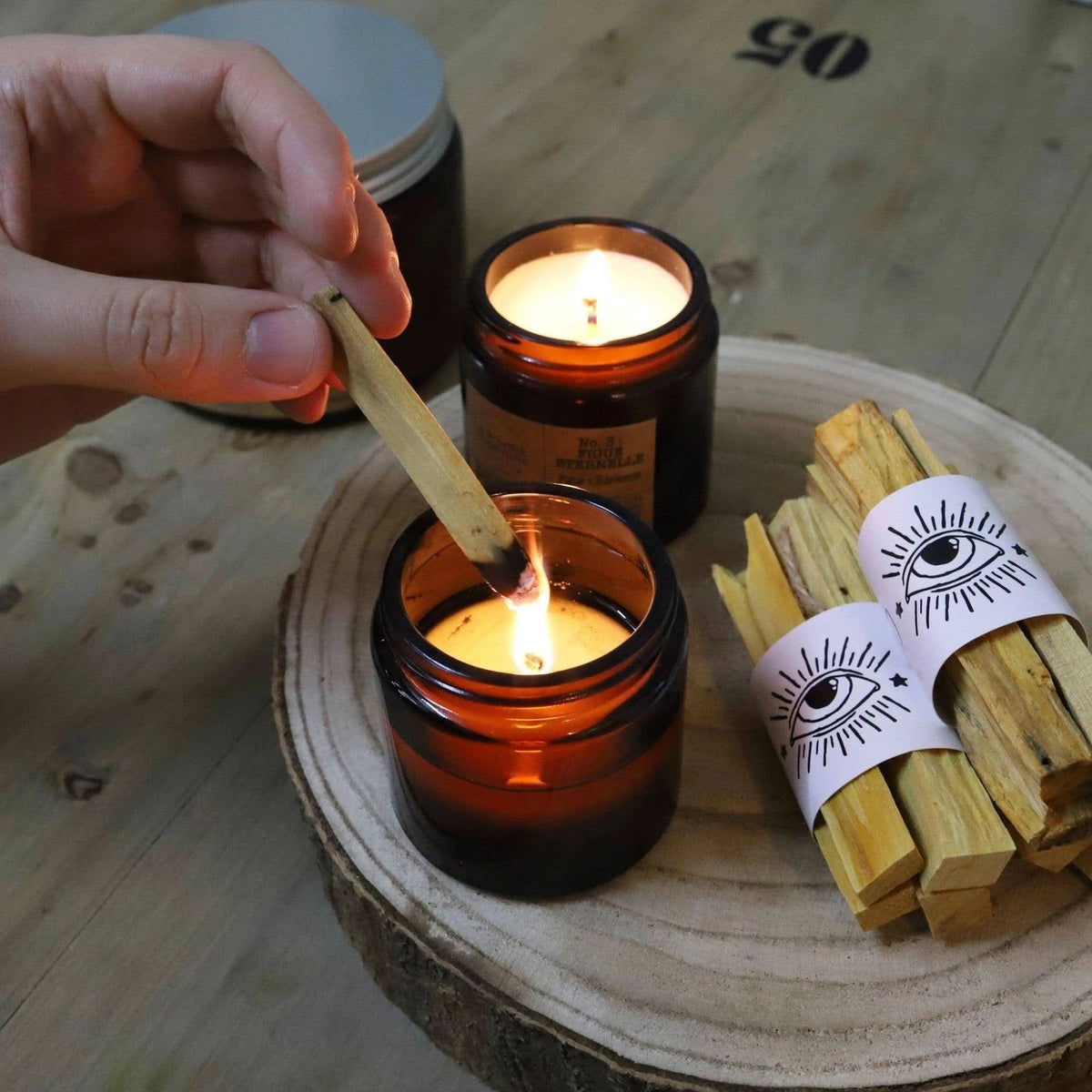 Allumage de bougie cire de soja sans parfum dans un pot en verre jaune sur une table en bois