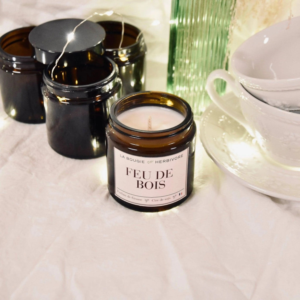Bougie parfumée feu de bois de La Bougie Herbivore dans un pot en verre, créant une ambiance chaleureuse