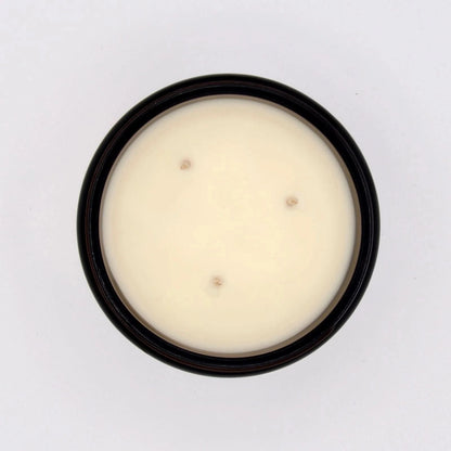 Bougie parfumée ambre teck dans un pot noir, avec trois mèches pour une combustion uniforme