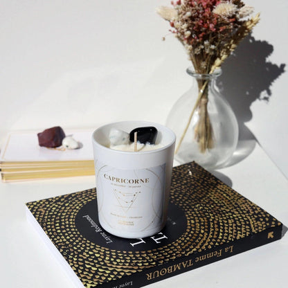 Bougie astrologique Capricorne avec cristaux sur un livre, ambiance zen et décorative