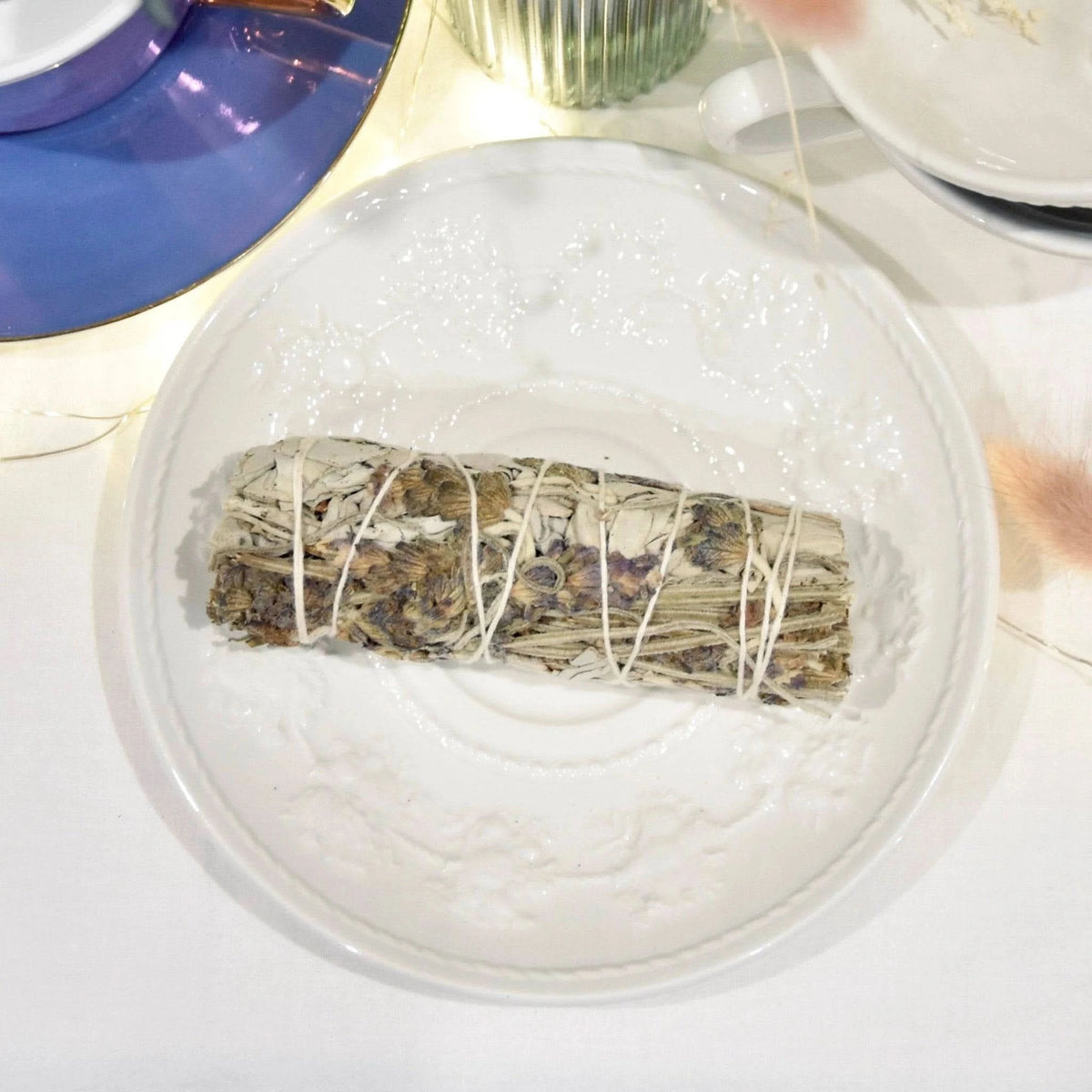 Fagot lavande apaisante présenté sur une assiette blanche avec des éléments décoratifs en arrière-plan
