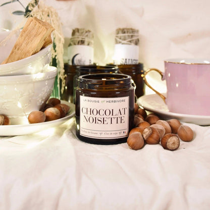 Bougie chocolat noisettes de La Bougie Herbivore, parfum chocolat et noisette, présentée avec des noisettes