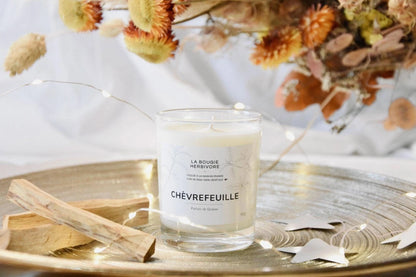 Bougie cire de soja naturelle La Bougie Herbivore, parfum chèvrefeuille en verre sur un plateau doré.