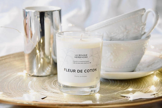 Bougie parfumée fleur de coton 150g de La Bougie Herbivore sur un plateau décoratif avec des tasses en porcelaine