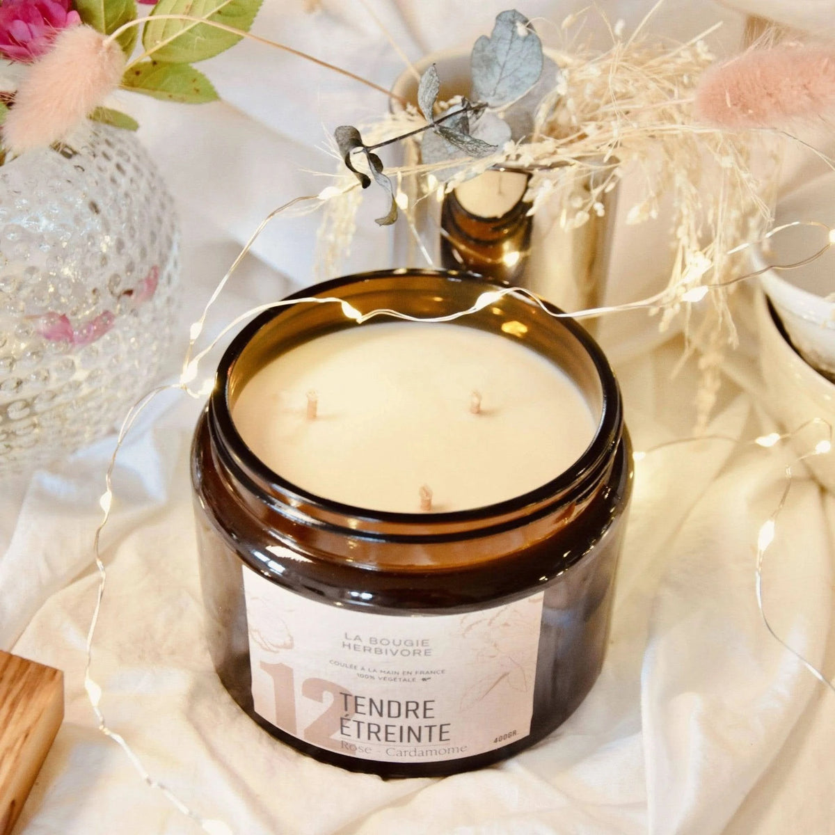 Bougie rose cardamome de La Bougie Herbivore dans un pot en verre élégant avec trois mèches