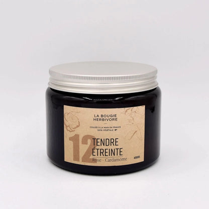 Bougie rose cardamome de La Bougie Herbivore dans un pot en verre noir avec couvercle blanc