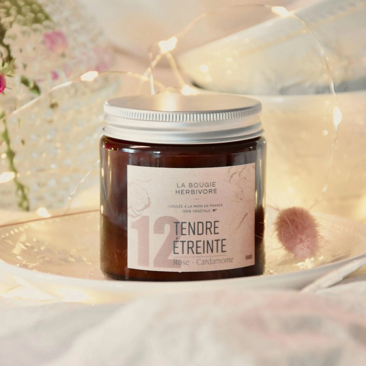 Bougie rose cardamome de La Bougie Herbivore dans un pot élégant, créant une ambiance chaleureuse, 90g