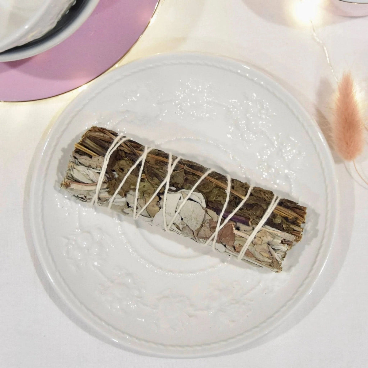 Bâtonnet d'encens La Bougie Herbivore sauge blanche et menthe purification sur une assiette décorative